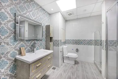 a bathroom with a sink and a toilet and a mirror at FiveX Premium 4BR Beachfront Living at JBR in Dubai