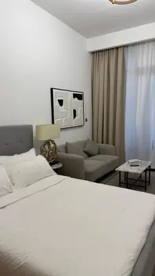 a bedroom with a white bed and a couch at VESTA - Dubai Residence in Dubai
