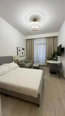 a bedroom with a large bed and a living room at VESTA - Dubai Residence in Dubai