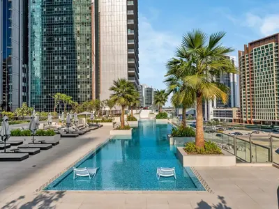 a swimming pool with palm trees and buildings at Cozy modern STUDIO in STERLING DOWNTOWN I DUBAI MALL I Sleeps 4 in Dubai