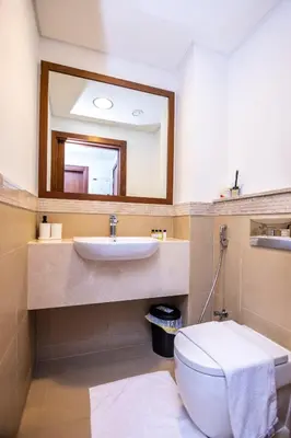a bathroom with a sink and a toilet and a mirror at Luxury 3 BR Premium Feel Iconic Burj View Connected To Dubai Mall in Dubai