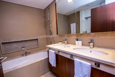 a bathroom with two sinks and a tub and a mirror at Luxury 3 BR Premium Feel Iconic Burj View Connected To Dubai Mall in Dubai