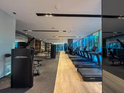 a gym with rows of treadmills and chairs at Grande Signature Residences in Dubai