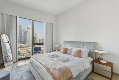 a bedroom with a large bed with a large window at Grande Signature Residences in Dubai
