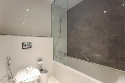a bathroom with a shower and a toilet and a sink at Elite LUX Holiday Homes - Stylish 1BR Living in Amna Tower, Al Habtoor City in Dubai