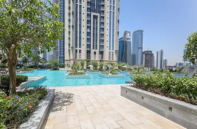 a swimming pool in a city with tall buildings at Elite LUX Holiday Homes - Stylish 1BR Living in Amna Tower, Al Habtoor City in Dubai