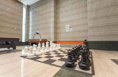 a chess board is on a chessboard in a room at Elite LUX Holiday Homes - Stylish 1BR Living in Amna Tower, Al Habtoor City in Dubai