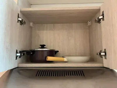 a pot and a bowl on a shelf in a kitchen at Cozy Studio with Private Beach in Dubai