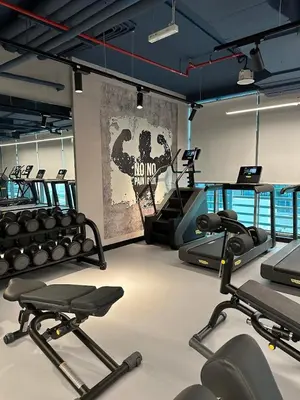 a gym with several treadmills and machines in a room at Beach access, next to shopping mall in Dubai