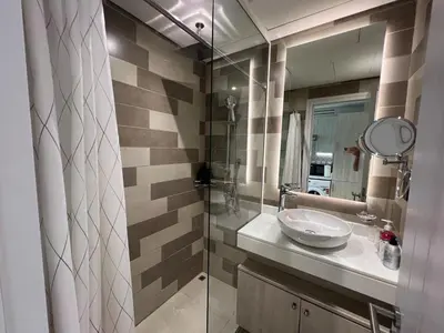 a bathroom with a sink and a glass shower at Beach access, next to shopping mall in Dubai