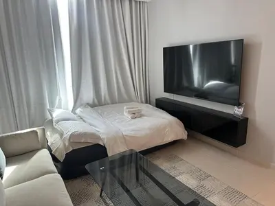 a living room with a couch and a tv at Next to Marina Mall, Close to beach and Metro in Dubai