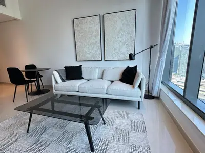 a living room with a white couch and a table at Next to Marina Mall, Close to beach and Metro in Dubai