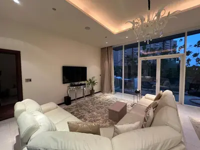 a living room with a white couch and a tv at Private beach, Close to Shopping Mall in Dubai
