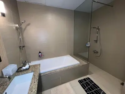 a bathroom with a bath tub and a shower at Private beach, Close to Shopping Mall in Dubai