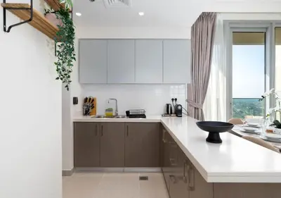 a kitchen with white counters and a large window at Forte Luxury 2BR Apartment with Skyline City Views near Dubai Mall in Dubai