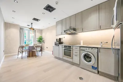 a kitchen with a washer and dryer next to a table at Ample space 2BR Princess towers Marina in Dubai