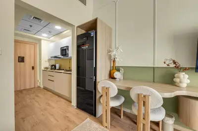 a kitchen with a counter with two chairs and a counter top at Waves - Modern Studio Retreat W Pool & Gym Access in Dubai