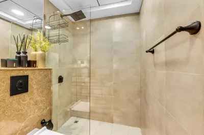 a bathroom with a shower with a glass door at Waves - Modern Studio Retreat W Pool & Gym Access in Dubai