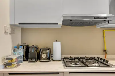 a kitchen counter top with a stove top oven at Waves - Modern Studio Retreat W Pool & Gym Access in Dubai