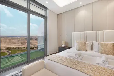 a bedroom with a white bed and a large window at Nobles Suites By Hostiva in Dubai