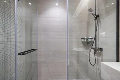 a shower with a glass door in a bathroom at Nobles Suites By Hostiva in Dubai