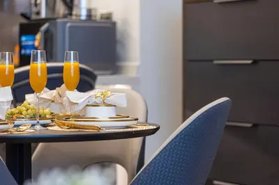a table with glasses of champagne and a plate of food at Nobles Suites By Hostiva in Dubai