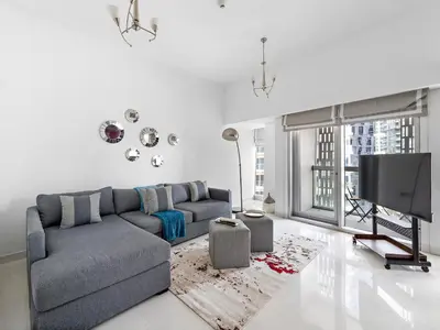 a living room with a couch and a tv at Skyline Marina - Modern 2BR Retreat In Cayan-33 in Dubai
