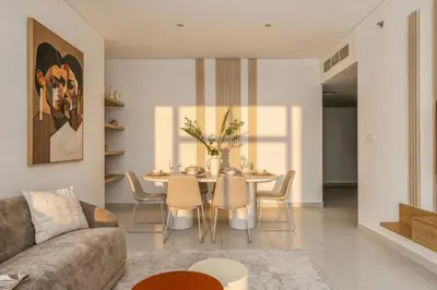 a living room with a table and chairs at 3 Bedroom Hotel Apartment with Gym, Spa and Pool in Dubai