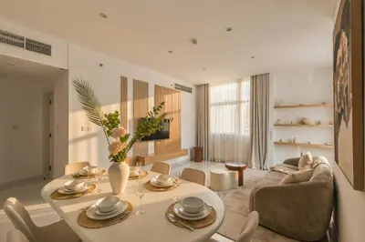 a living room with a table and a couch at 3 Bedroom Hotel Apartment with Gym, Spa and Pool in Dubai