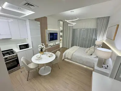 a room with a bed and a table with chairs at Brand New Studio Downtown, All Bills Included in Dubai