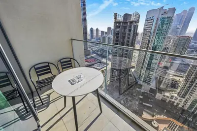 a balcony with a table and chairs and a view of a city at CH Skyline Bliss 1 BR near Burj Khalifa in Dubai