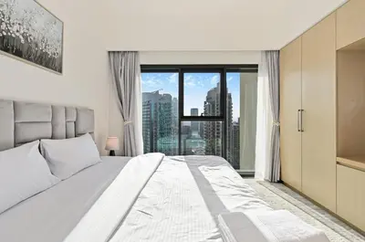 a bedroom with a white bed and a large window at CH Skyline Bliss 1 BR near Burj Khalifa in Dubai