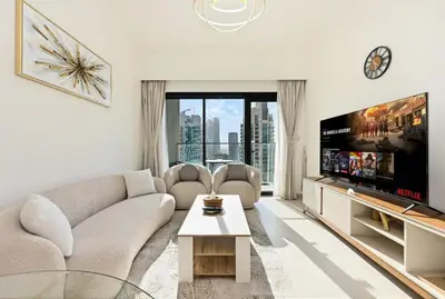 a living room with a large tv and a couch at CH Skyline Bliss 1 BR near Burj Khalifa in Dubai