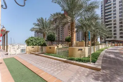 a sidewalk with palm trees and a fence at Luxury Apartment in Palm Jumeirah, Breathtaking Sea Views in Dubai