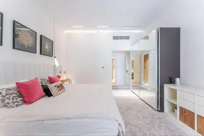 a bedroom with a large white bed with pink pillows at Luxury Apartment in Palm Jumeirah, Breathtaking Sea Views in Dubai