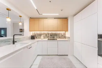 a white kitchen with white cabinets and a sink at Luxury Apartment in Palm Jumeirah, Breathtaking Sea Views in Dubai