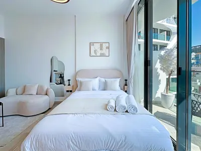 a bedroom with a large white bed with shoes on it at Stylish Contemporary Studio in Oxford Gardens in Dubai