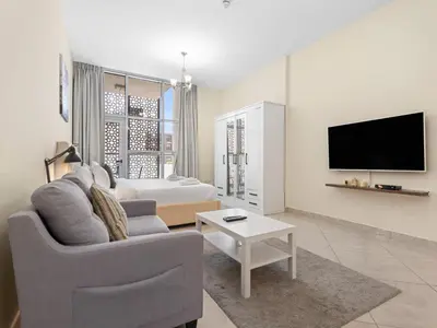 a living room with a couch and a tv at The Cozy Corner Studio In Chaimaa in Dubai