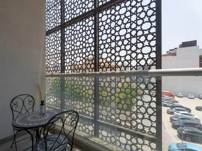a balcony with a table and chairs and a view of a parking lot at The Cozy Corner Studio In Chaimaa in Dubai