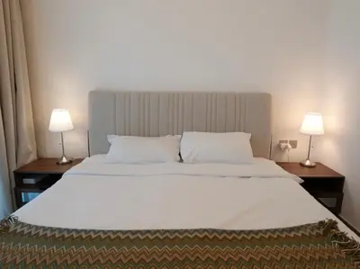 a bedroom with a large white bed with two lamps at Urban Oasis by Missoni in Dubai