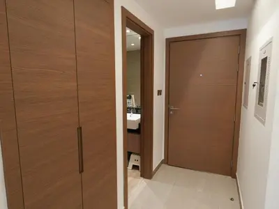a bathroom with a wooden door and a sink at Urban Oasis by Missoni in Dubai