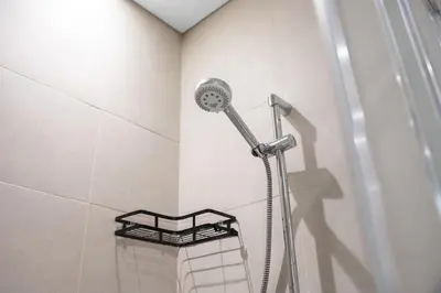 a shower with a shower head in a bathroom at Elegant 1BR Near Downtown Azizi Riviera 3 in Dubai