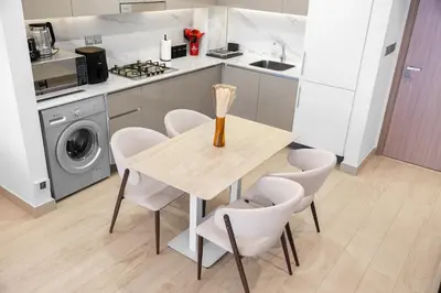 a kitchen with a table and chairs in a kitchen at Elegant 1BR Near Downtown Azizi Riviera 3 in Dubai