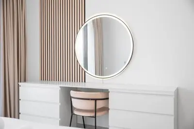 a dressing table with a mirror and a chair at Elegant 1BR Near Downtown Azizi Riviera 3 in Dubai