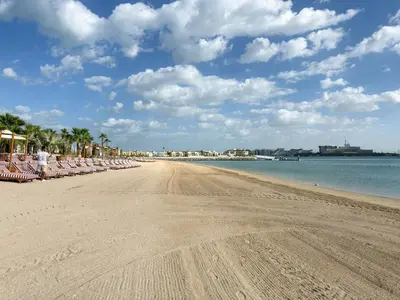 a sandy beach with chairs and the ocean at LUX Seaview Studio - Beach Access in Dubai