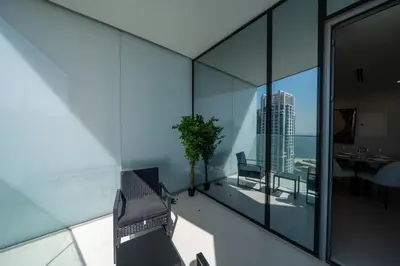 a room with glass walls and a table and chairs at Homes Beyond l Marina Luxe 1BR at LIV in Dubai