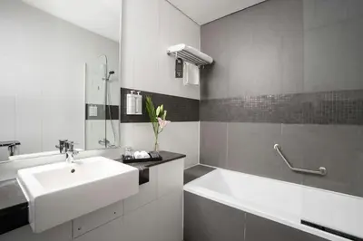 a white bathroom with a sink and a tub at The First Collection Marina, Dubai, a Tribute Portfolio Hotel in Dubai