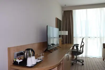 a hotel room with a desk with a television on it at Hilton Garden Inn Dubai, Mall Avenue in Dubai