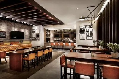 a restaurant with tables and chairs and a bar at Hilton Garden Inn Dubai, Mall Avenue in Dubai