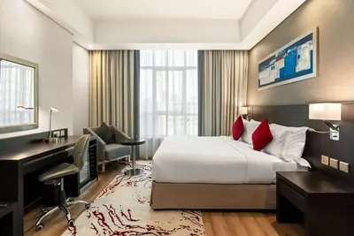 a hotel room with a bed and a desk and a computer at Ramada by Wyndham Dubai Barsha Heights in Dubai